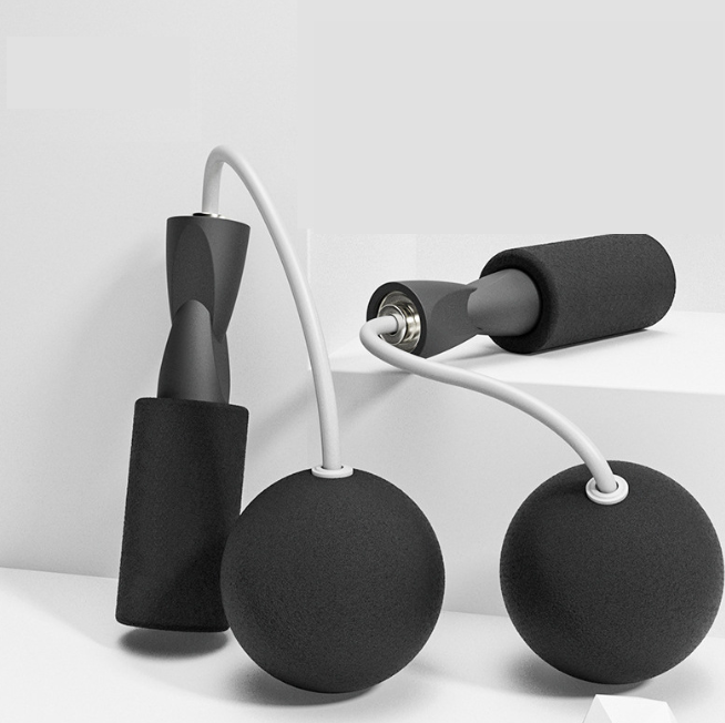 Black cordless skipping rope with foam grips and dual-use design, set against a minimal backdrop by PureAura.
