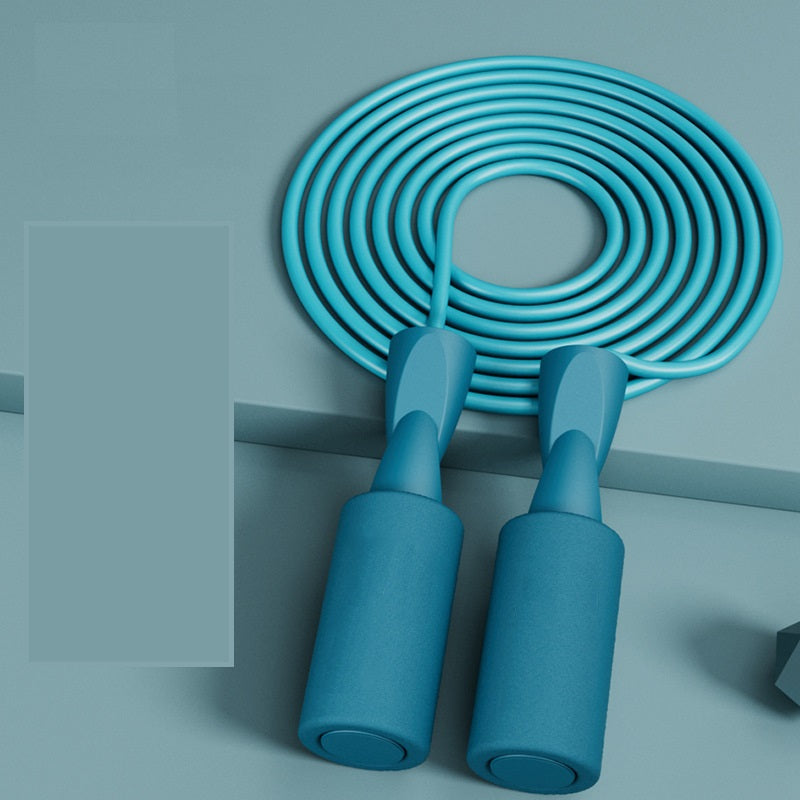 A vibrant blue Cordless Dual-use Skipping Rope coiled on a surface, highlighting its ergonomic grips by PureAura.