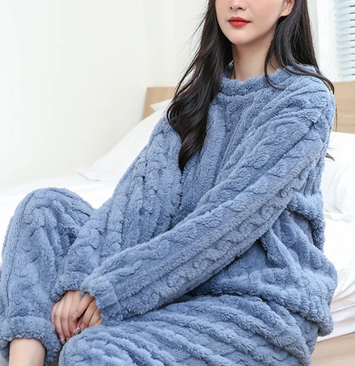 Cozy model in a blue Winter Coral Velvet Pajama Set, featuring a warm pullover and pants by PureAura.