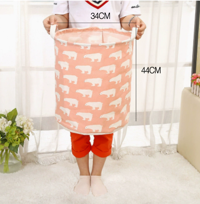 Large capacity cotton linen laundry basket in pink with polar bear design, held by a person, by PureAura.