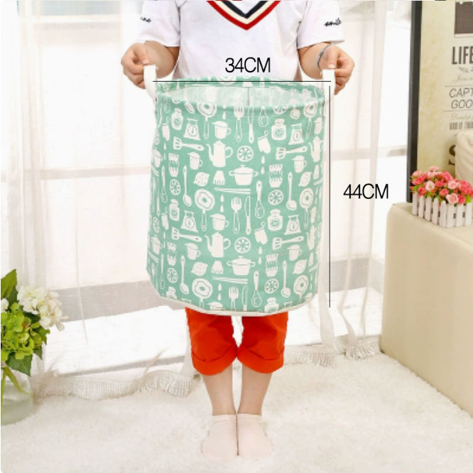 A light mint laundry basket with kitchen utensil patterns held by a person, showcasing its size. Large Capacity Cotton Linen 