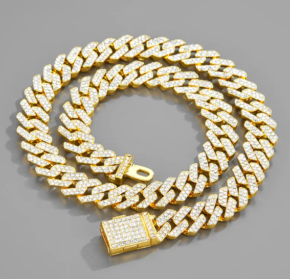 Shiny gold chain necklace with sparkling crystals, elegantly displayed on a gray surface, by PureAura.