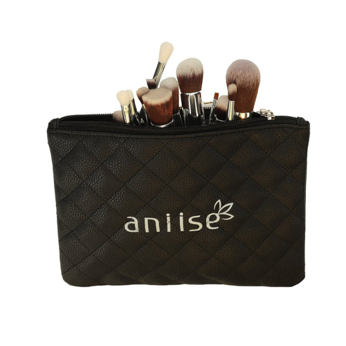 A collection of professional synthetic makeup brushes peeking from a black quilted pouch labeled aniise.