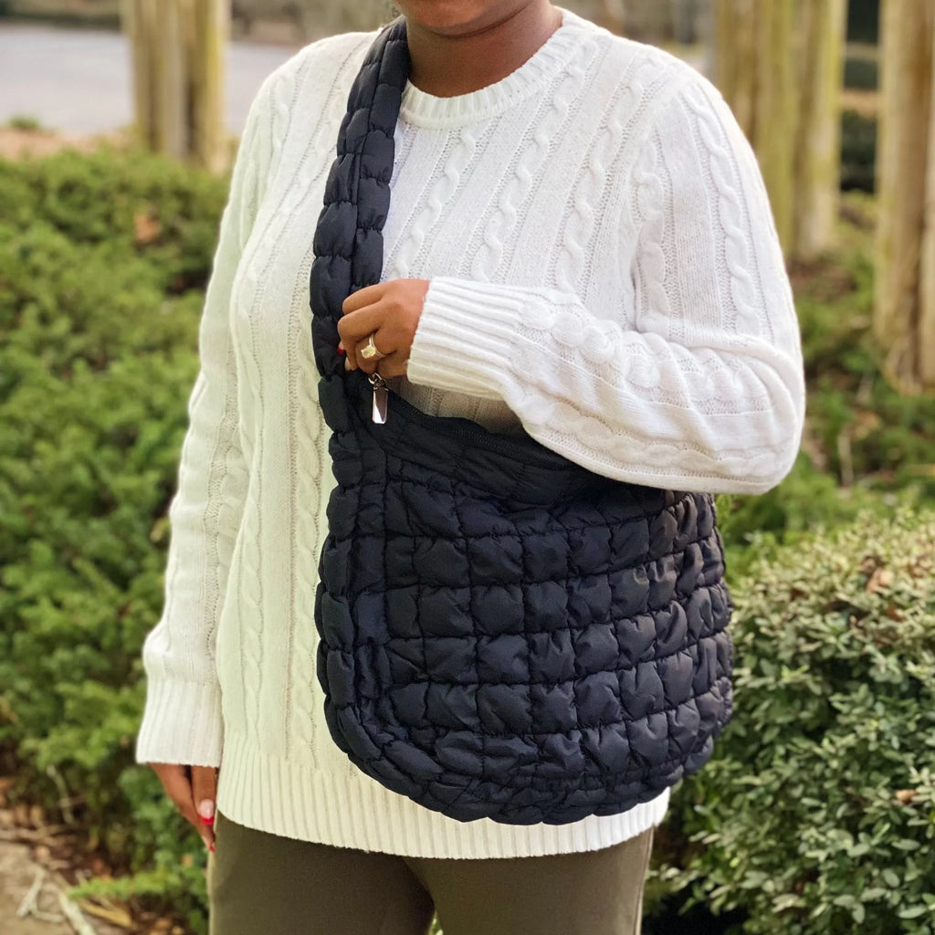 A woman wearing a cozy white sweater holds a stylish black Carry All Quilted Cross Body Bag by My Store.