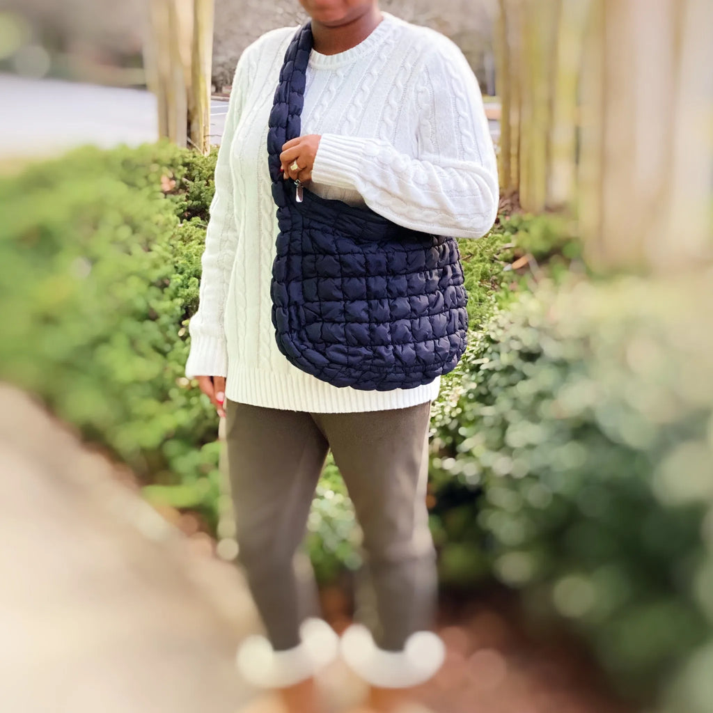 A model holds a navy Carry All Quilted Cross Body Bag, showcasing its stylish quilted design outdoors by My Store.