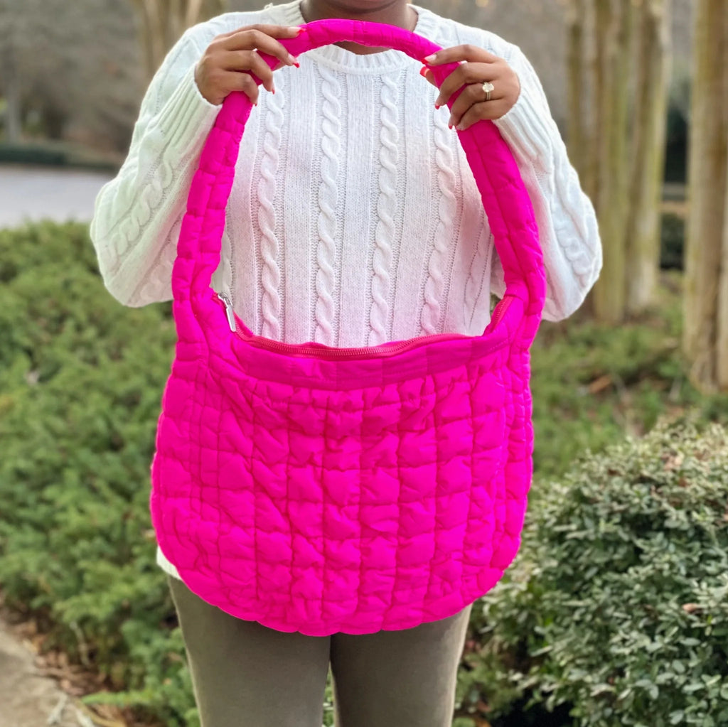 A model holds a vibrant pink Carry All Quilted Cross Body Bag, showcasing its unique quilted design by My Store.